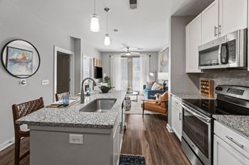 A modern kitchen with granite countertops and stainless steel appliances.